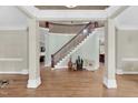 Spacious foyer with elegant staircase, hardwood floors, and decorative columns at 3324 Thomas Rd, Raleigh, NC 27607
