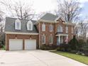 Traditional brick home with a two-car garage, landscaped yard, and inviting front porch at 3359 Hampton Rd, Raleigh, NC 27607