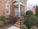 Inviting front porch with blue door, brick steps, and classic railing, enhancing curb appeal at 3359 Hampton Rd, Raleigh, NC 27607