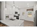 Bright kitchen with granite counters, white cabinets, stainless appliances, and hardwood floors at 521 Providence Springs Ln, Fuquay Varina, NC 27526