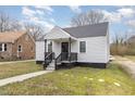 Well-kept home with gray siding, a covered porch, and a tidy lawn on a sunny day at 628 East Ave, Henderson, NC 27536