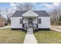 Charming home showcasing gray siding, covered entry, and a neatly maintained front lawn at 628 East Ave, Henderson, NC 27536