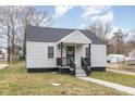 A cozy home with gray siding, a covered front porch, and a manicured lawn at 628 East Ave, Henderson, NC 27536