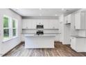 Modern kitchen with white cabinets, stainless steel appliances, granite countertops, and a kitchen island at 631 Contento Ct, Sanford, NC 27330