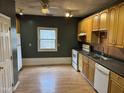 View of kitchen features wood cabinets, laminate wood floors, and white appliances at 731 Latimer St, Hillsborough, NC 27278