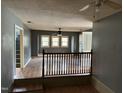 Spacious living room featuring hardwood floors, three windows, and a ceiling fan at 731 Latimer St, Hillsborough, NC 27278