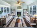 Staged living room featuring a fireplace, vaulted ceilings, and large windows for natural light at 1125 Field Meadows Dr, Zebulon, NC 27597