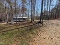 Landscape view of the front of the home, surrounded by many trees in a quiet environment at 122 Tomahawk Dr, Louisburg, NC 27549