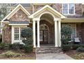 Inviting front porch with stone steps, elegant columns, and a charming entryway that create a warm and welcoming curb appeal at 12417 Richmond Run Dr, Raleigh, NC 27614