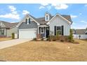 Inviting home featuring a two-car garage, brick accents, and well-maintained front yard at 133 Alumroot Road Rd, Holly Springs, NC 27540