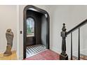 Elegant entryway showcasing black and white checkered floors, an arched doorway, and a stylish staircase at 1354 Briar Chapel Pkwy, Chapel Hill, NC 27516