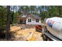 Construction site displaying new home with brick foundation, heavy equipment, and building materials at 15 Bourbon St, Fuquay Varina, NC 27526