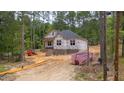 Construction in progress shows the exterior framing, brick foundation, and wood materials at 15 Bourbon St, Fuquay Varina, NC 27526