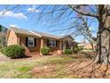 Charming brick home featuring classic design with landscaped yard and mature trees at 2103 Huntington Rd, Burlington, NC 27215