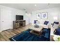 A bright living room with a plush blue rug and a comfortable sofa accented with blue pillows at 217 Elyse Overlook Loop, Sanford, NC 27332