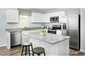 Modern kitchen with white cabinets, stainless steel appliances, granite countertops, and a breakfast bar at 219 Elyse Overlook Loop, Sanford, NC 27332