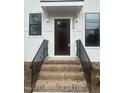 Elegant entryway with brick steps, black metal railings, and a dark wood front door at 2214 Woodrow St, Durham, NC 27705