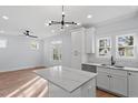 Modern kitchen featuring white cabinetry, a marble-topped island, and contemporary lighting at 2218 Woodrow St, Durham, NC 27705