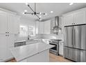 Gourmet kitchen with stainless steel appliances and stylish white cabinetry with marble countertops at 2218 Woodrow St, Durham, NC 27705