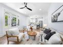 Bright, open-concept living area with hardwood floors, white walls, modern fan, and access to the kitchen at 2218 Woodrow St, Durham, NC 27705
