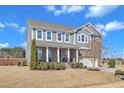 Charming two-story home featuring a landscaped yard, covered front porch, and attached two-car garage at 2220 Stillness Pond Ln, Apex, NC 27539