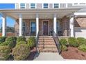 Inviting front porch with brick stairs, decorative railing, and space for seating at 2220 Stillness Pond Ln, Apex, NC 27539