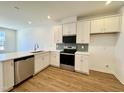 Bright kitchen featuring stainless steel appliances, white cabinets, and a stylish backsplash at 2353 Whitewing Ln, Wendell, NC 27591