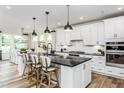Modern kitchen featuring a large island with seating, stainless steel appliances, and stylish pendant lighting at 2404 Del Webb Gardens Dr, Fuquay Varina, NC 27526