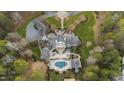 A sprawling estate featuring a luxurious home, swimming pool, meticulously landscaped gardens, and circular driveway at 266 Perfect Moment Dr, Durham, NC 27713