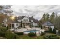 Luxury home featuring a pool, manicured backyard, covered patio, and beautifully designed landscaping at 266 Perfect Moment Dr, Durham, NC 27713
