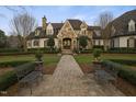 Elegant stone and white brick home featuring lush landscaping, walkway, and benches at 266 Perfect Moment Dr, Durham, NC 27713