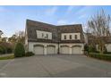 Three-car garage with carriage doors, white brick, and classic architectural details at 266 Perfect Moment Dr, Durham, NC 27713
