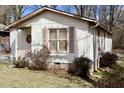 Quaint single story home showcasing light colored siding, complementing shutters, and a welcoming front porch at 309 Cody St, Durham, NC 27703