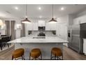 Bright kitchen features an island with granite countertops, pendant lighting, and stainless steel appliances at 424 Providence Springs Ln, Fuquay Varina, NC 27526