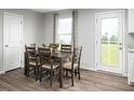 Cozy dining room with a wooden table, chairs, and natural light from a nearby doorway at 428 Autumn Moon Dr, Zebulon, NC 27597