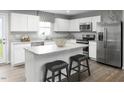 Modern kitchen with white cabinets, stainless steel appliances, and a center island with seating at 428 Autumn Moon Dr, Zebulon, NC 27597