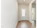 Bright hallway featuring wood-look flooring, leading to a glass door and a glimpse of a sunlit room at 504 Rhino Bnd, Oxford, NC 27565