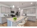Bright kitchen with stainless steel appliances, granite countertops, and pendant lighting at 505 Providence Springs Ln, Fuquay Varina, NC 27526