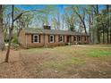 Side view of brick ranch with mature trees on a spacious lot at 513 W Glendale St, Siler City, NC 27344
