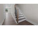 Beautiful home staircase featuring modern wood treads, white risers, and black iron balusters at 716 Jamescroft Way # 28, Rolesville, NC 27571