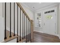 Staircase shot featuring wood treads, black railings, with natural light and a white front door at 716 Jamescroft Way # 28, Rolesville, NC 27571