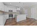 Modern kitchen with white cabinets, stainless steel appliances, and a center island at 718 Jamescroft Way # 29, Rolesville, NC 27571
