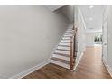 Bright foyer view of a wooden staircase with white risers and a black iron railing at 718 Jamescroft Way # 29, Rolesville, NC 27571