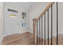 View of a staircase, showcasing a wooden handrail, black iron spindles, and natural light at 718 Jamescroft Way # 29, Rolesville, NC 27571