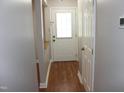 Well-lit hallway features hardwood floors and neutral paint, leading to a bright front door at 7746 Kingsberry Ct, Raleigh, NC 27615