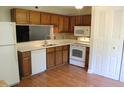 Functional kitchen with wood cabinets, white appliances, and a tiled backsplash at 7746 Kingsberry Ct, Raleigh, NC 27615