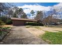 Exterior view of a single-story house with a driveway, well-maintained landscaping, and mature trees at 817 Glen Eden Dr, Raleigh, NC 27612