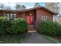 Inviting front entrance featuring double red doors, manicured bushes, and a concrete walkway at 817 Glen Eden Dr, Raleigh, NC 27612