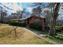 Well-maintained front yard with a lush lawn, mature trees, and landscaping surrounding a charming home at 817 Glen Eden Dr, Raleigh, NC 27612