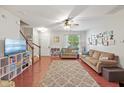 Spacious living room featuring hardwood floors, a ceiling fan, and staircase at 1007 Denmark Manor Dr, Morrisville, NC 27560